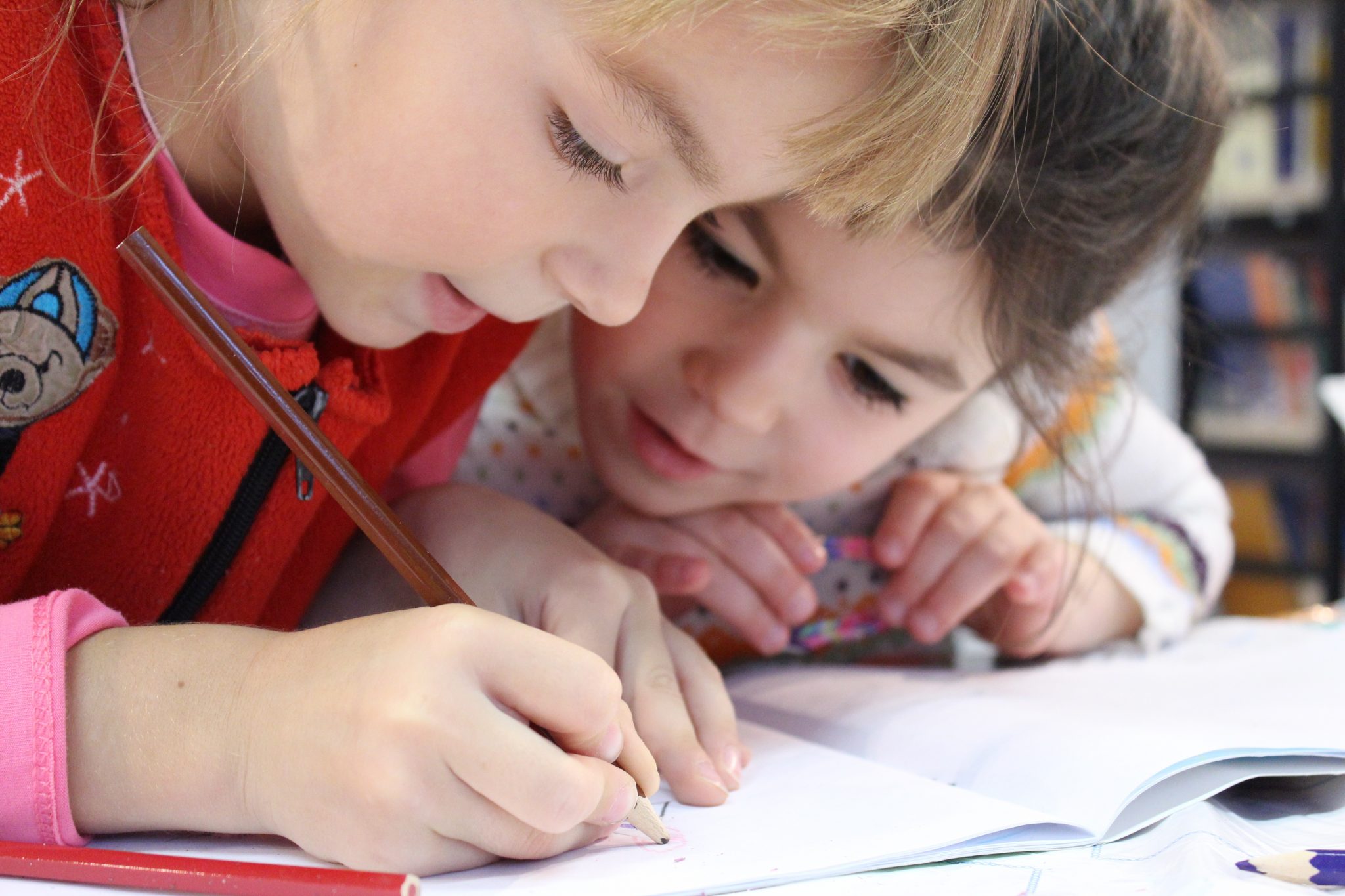 Canva - Two Kids Writing on a Notebook