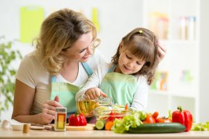 mom and kid girl preparing healthy food at home