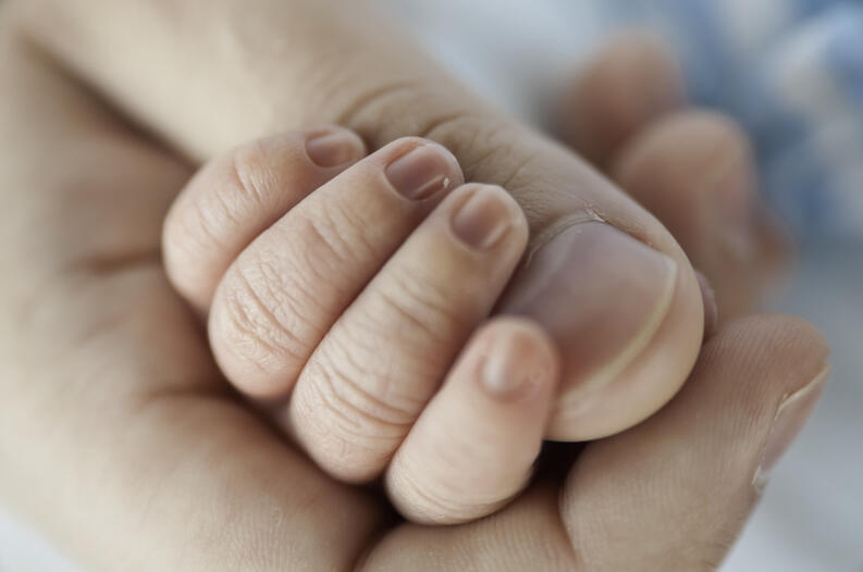 Father holding baby's hand