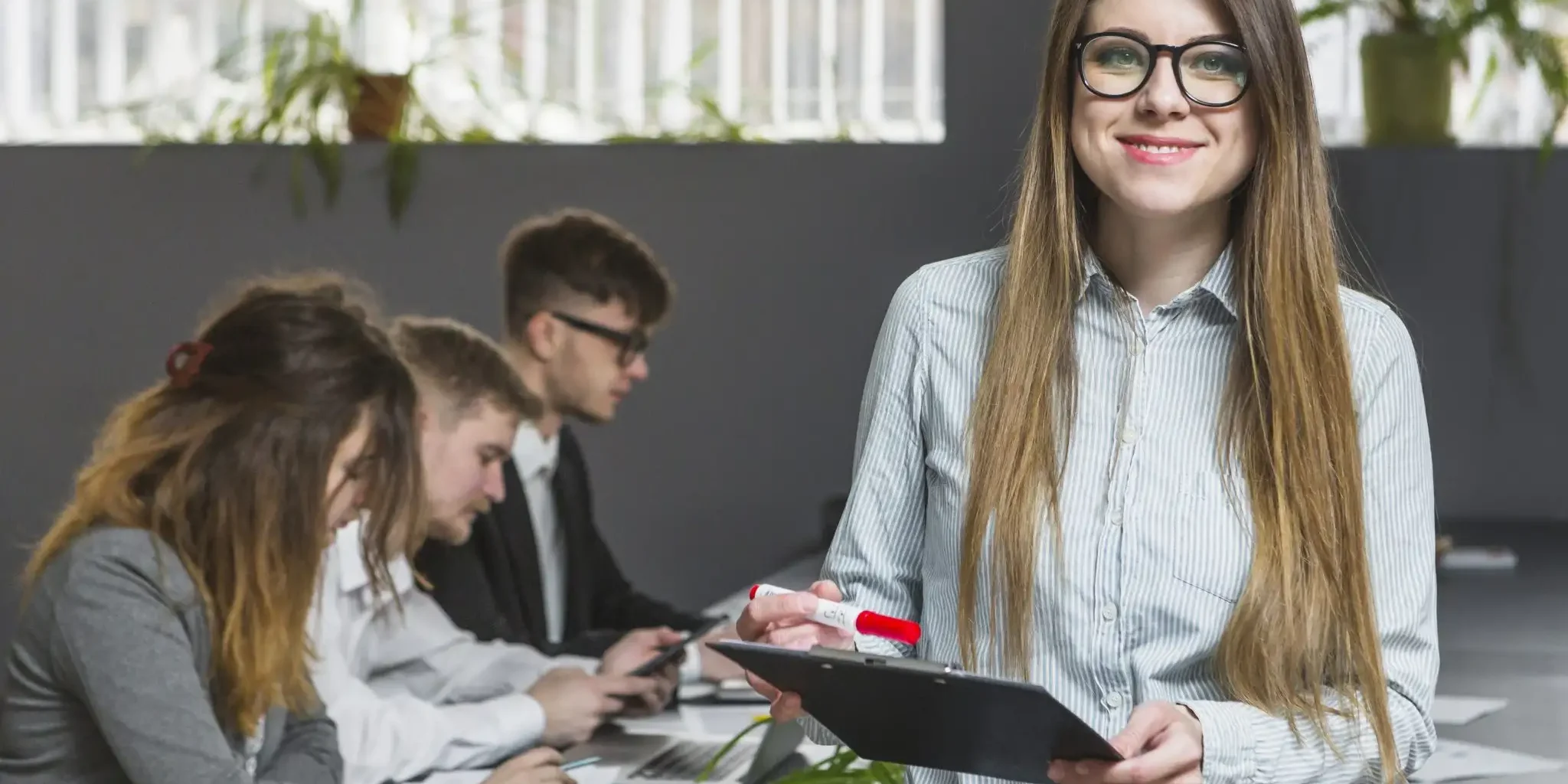 smiling-young-businesswoman-front-colleagues-working-office