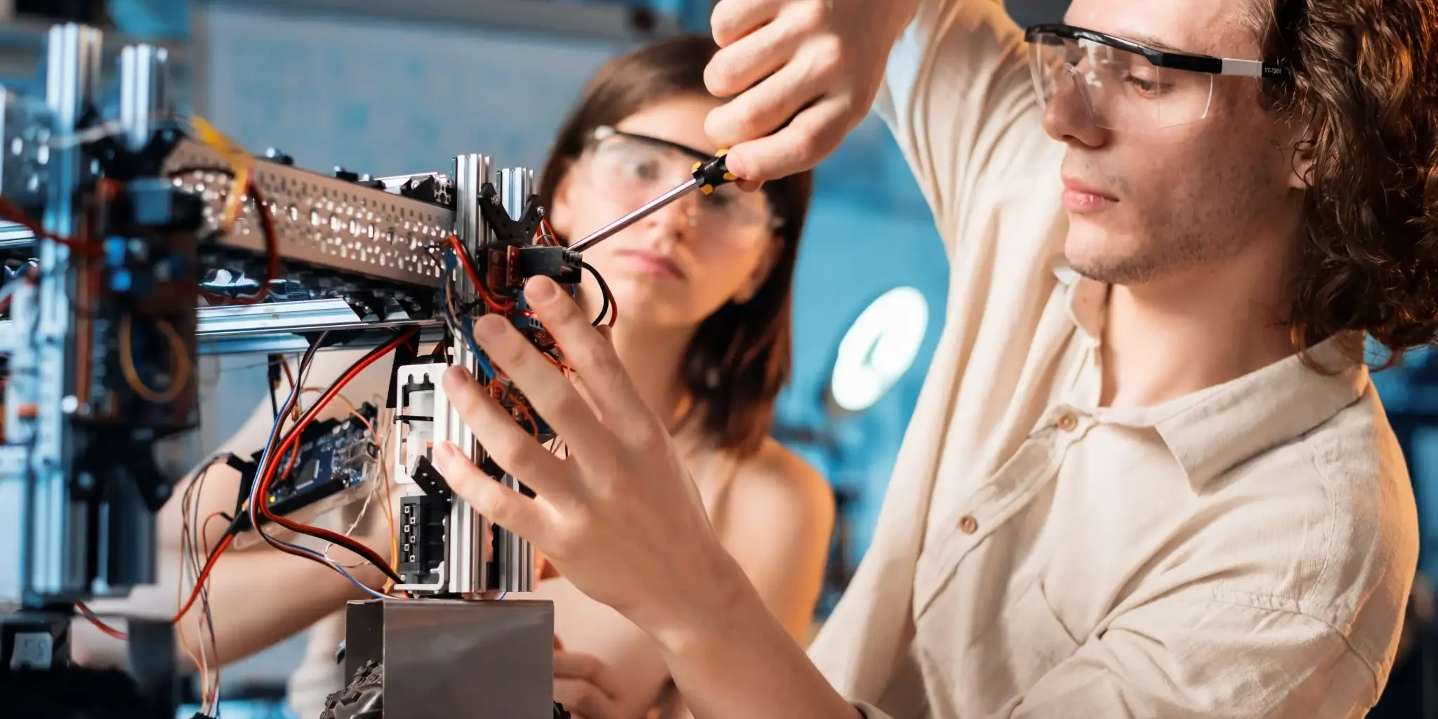 young-man-woman-protective-glasses-doing-experiments-robotics-laboratory-robot
